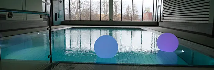 En blå och en lila flytande boll i en bassäng
