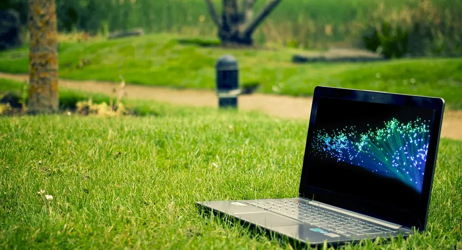 En laptop som står öppen på gräsmatta