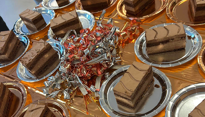 Chokladtårta i bitar på assietter med glittriga dekorationer på bordet