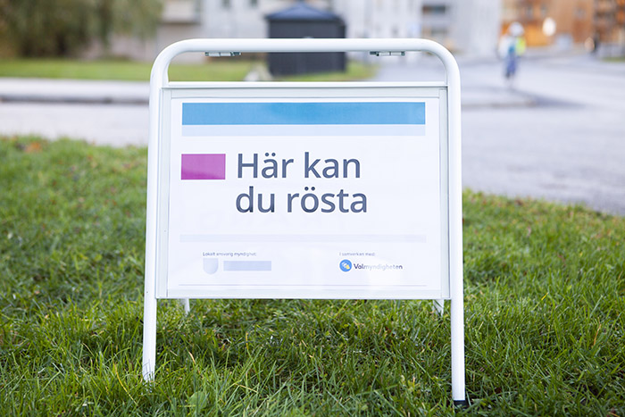 Skylt trottoarpratare med text Här kan du rösta.