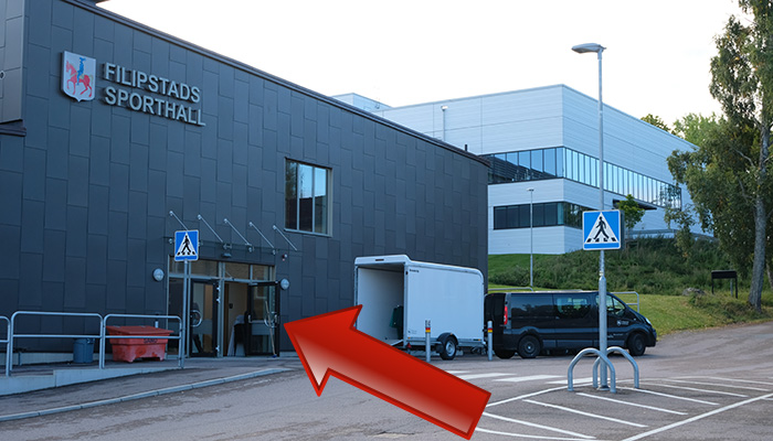 Grå byggnad och röd pil som pekar på entrén.