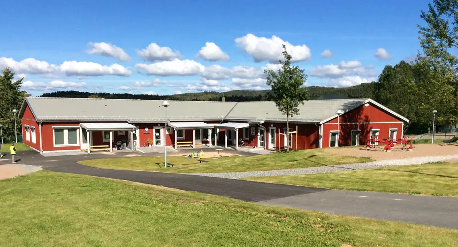 Förskolan Lyckan rött enplans hus med vita knutar och gräsmatta runt omkring