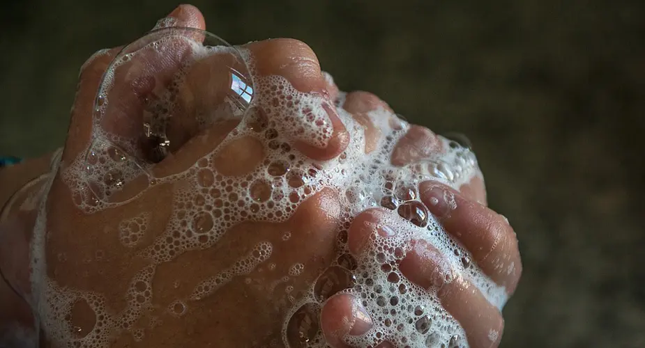 Närbild på person som tvättar händerna med mycket lödder från tvålen