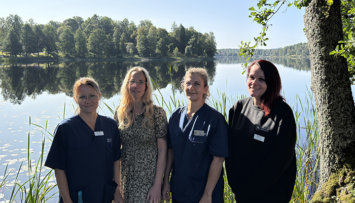Fyra personer står framför en sjö.