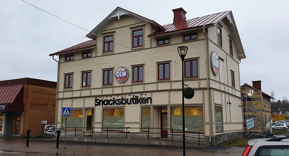 Nymålad beige byggnad med skyltar det står OLW och Snacksbutiken på