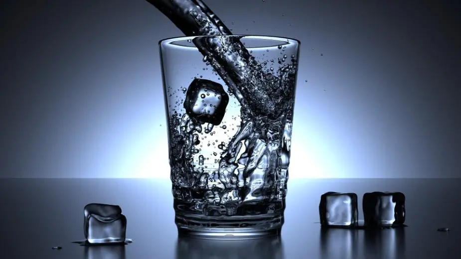 Vatten som hälls i glas med isbitar