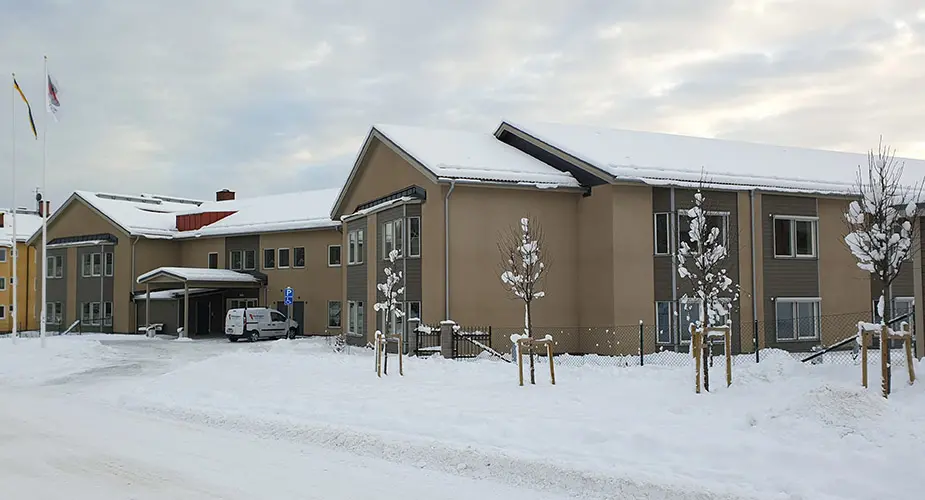 Fridensborg som är en brun byggnad med en snöig väg framför
