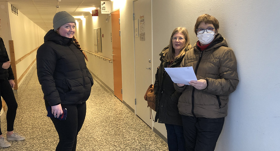 Två personer från Lottakåren tar emot en vårdpersonal i en korridor