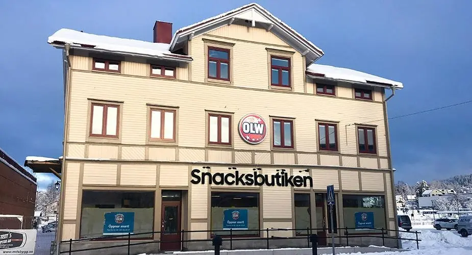 Beige byggnad med skylt Snacksbutiken och logotyp OLW