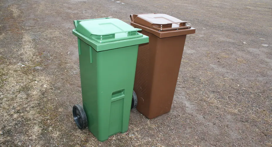 Ett brunt sopkärl för kompost och ett grönt för hushållsavfall