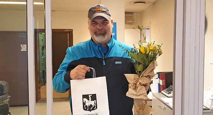 Björn Engström vinnare i namntävlingen för idrottshallen. Håller i gula blommor och påse med presentkort